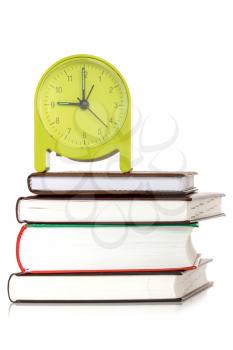 Green clock and  books on a white background 