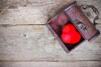 Red heart  in the old  box on the wooden floor