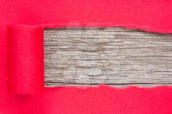 Red paper torn to reveal wooden panel for copy space	