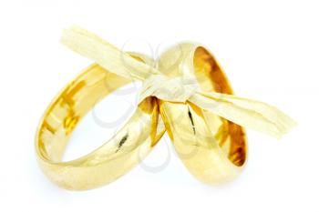 Two golden wedding rings tied with bow. Isolated on white background