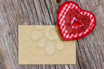 Red heart and paper piece for your text on a wood background