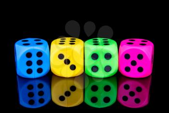 Four colorful dice, isolated on black background