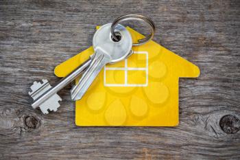 Keys and  house symbol  on wood background 