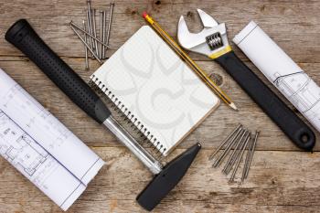 Tools , twisted technical drawing and blank notebook 