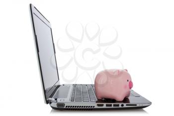 Online savings concept. Piggy bank sitting on  laptop over a white background.