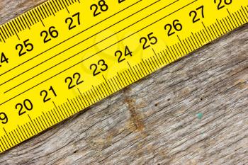 Close-up yellow ruler on a wooden background