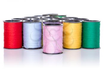 Colorful bobbins with needle, isolated on white background