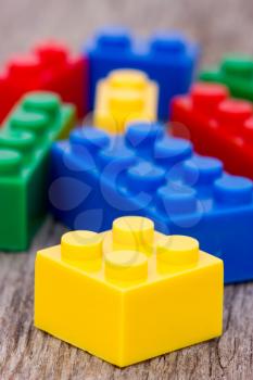 Color plastic building blocks on wooden background