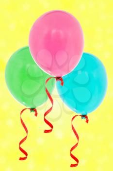 Colorful inflatable balloons flying on the yellow background