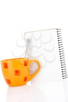 Orange coffee cup with a notebook on white background