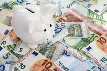 Piggy bank placed on Euro currency. Concept for cut in interest rates, euro crisis and saving
