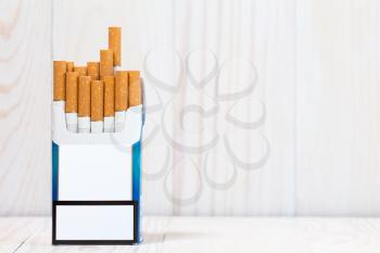Pack of cigarettes on white wood  background. With copy-space for text