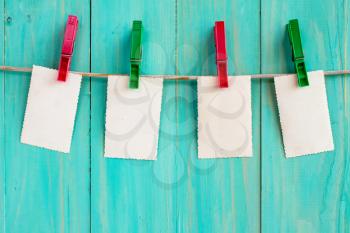 Photo frames hanging on a rope over blue wooden background