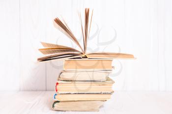 Old books stacked on white wooden  background, knowledge concept