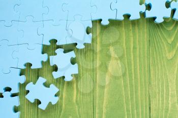 Puzzle on green wooden background.Team business concept