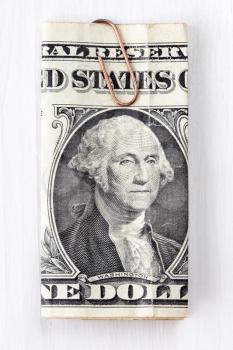 USA one dollar bill with paper-clip on wooden  background