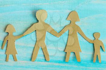 Cardboard figures of the family on a bluewooden background