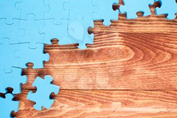 Puzzle on brown wooden background.Team business concept