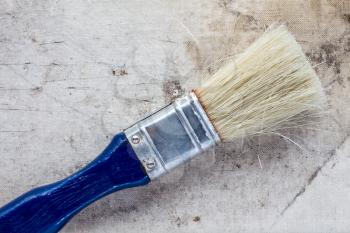 Paint brush on a dirty canvas surface, close up