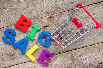 Shopping cart and plastic letters spelling BIG SALE