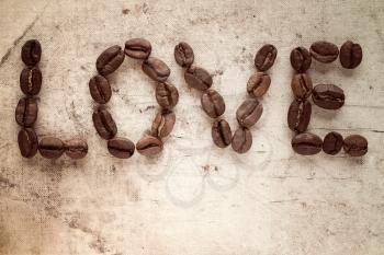 Coffee beans  used to spell love on canvas background with copy-space