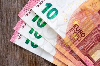 Ten euros notes laid on the wooden background