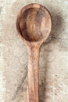 Wooden spoon over textured background, from above