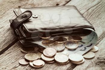 Black wallet with euro currency on the wooden background