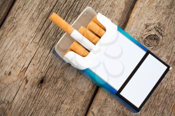 Open pack of cigarettes with cigarettes sticking out. Copy space for your text.