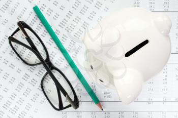 Financial reports,glasses,pencil and piggy bank. Concept for economy and savings