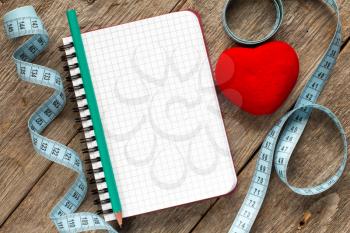 Measure tape,pen,red heart and blank notebook for your resolutions 