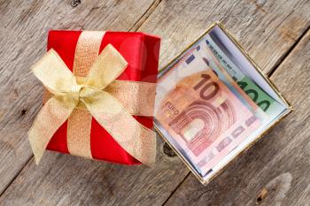 Open Giftbox with  Euro currency on the wooden background