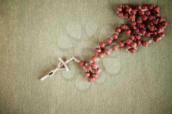 Catholic rosary on dark green background with copy-space for your text