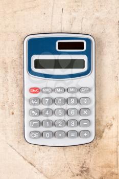 Electronic digital calculator on dirty canvas background