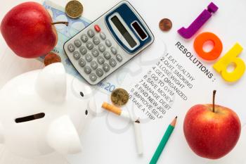 Piggy-bank,apples and office supply on list of resolutions 