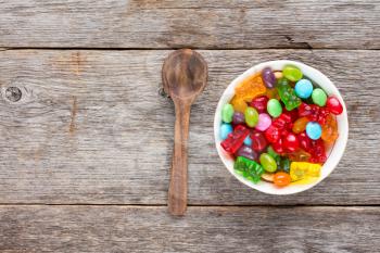 Wooden spoon and bowl full of colorful candies