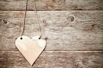  Heart made of paper hanging on wooden background.Copy-space.