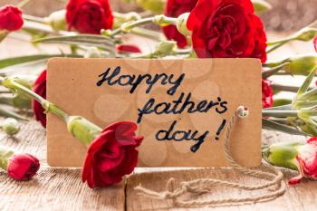 Father's day card with carnations on wooden board