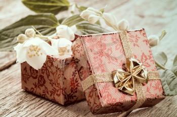 Open gift box and wild flower on a wooden background