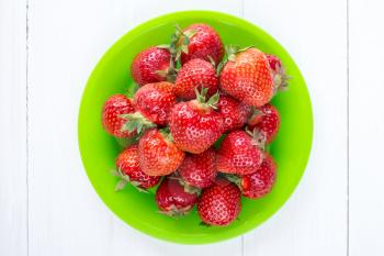 Top view of green plate with fresh strawberries