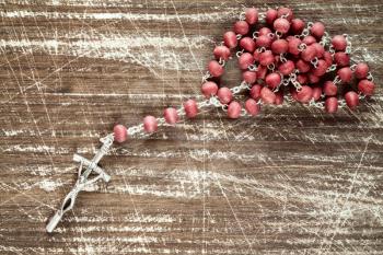 Old wooden scratched background and catholic rosary