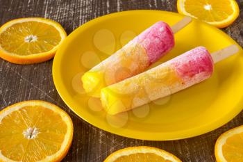 Popsicles with sliced orange fruit on  wooden background. Summer food concept. 