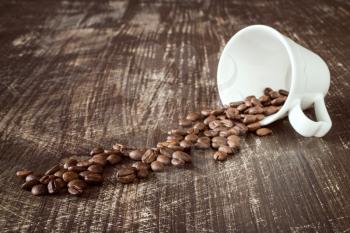 Coffee-cup and roasted coffee beans on a wooden background.