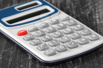 Close-up view of electronic calculator on wooden background. 