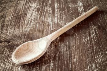 Big wooden spoon on the scratched wooden table