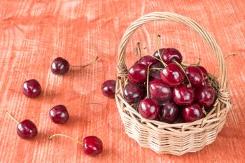 Wicker basket of fresh cherry fruit on the table