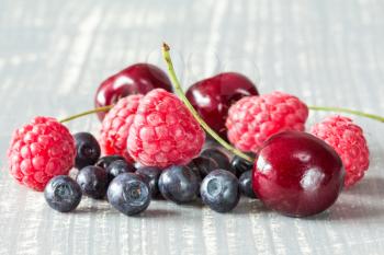 Close-up pile of summer berries on wooden background