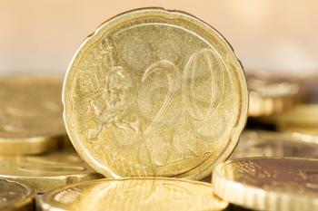  Closeup of a 20 euro cent coin standing between other coins
