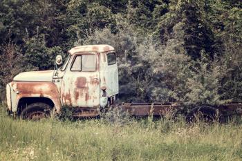 Abandoned old truck rusting in a field