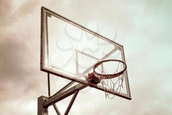 Basketball hoop against a dramatic cloud-filled sky